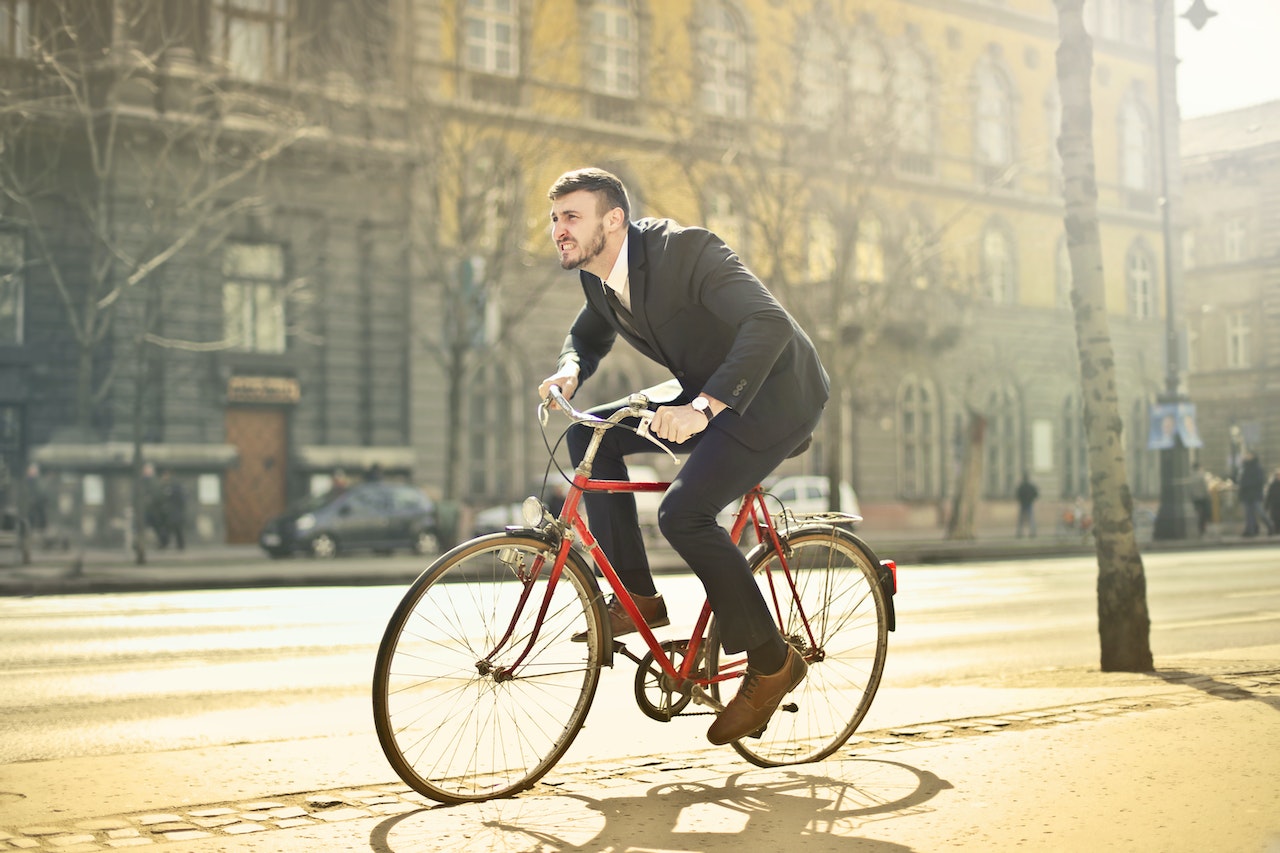 man in pak op fiets in de stad